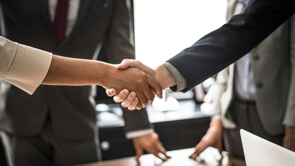 mãos se cumprimentando em um escritório e expressando o networking: uma das tendências da transformação digital