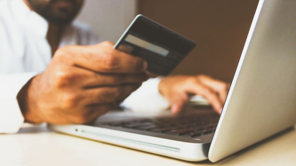 Homem utiliza seu cartão de crédito para fazer uma compra online e aproveitar as entregas rápidas.