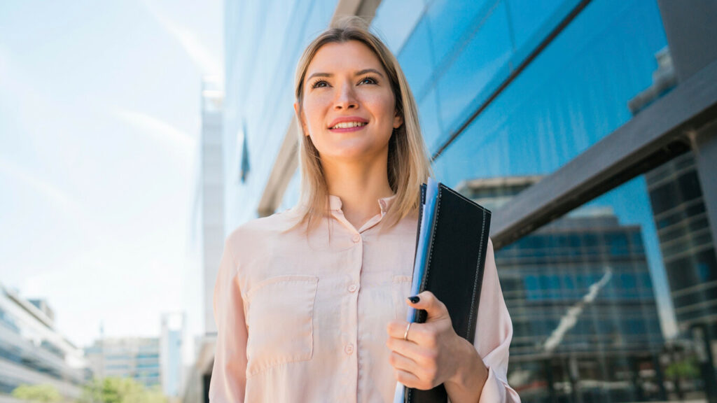 Mulher loira com olhar de orgulho por ter experiência internacional no currículo