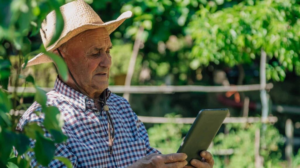 Idoso utiliza tablet no trabalho após aprender Ciência de Dados.