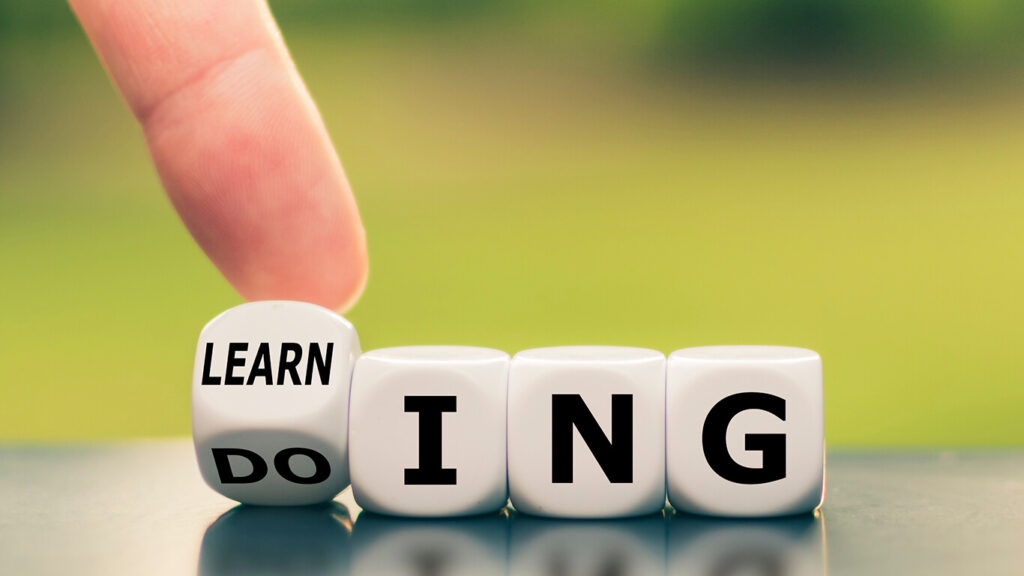 Na imagem, dados representando o aprendizado contínuo, com letras em cada dado que formam o conceito 'Do Learning'.