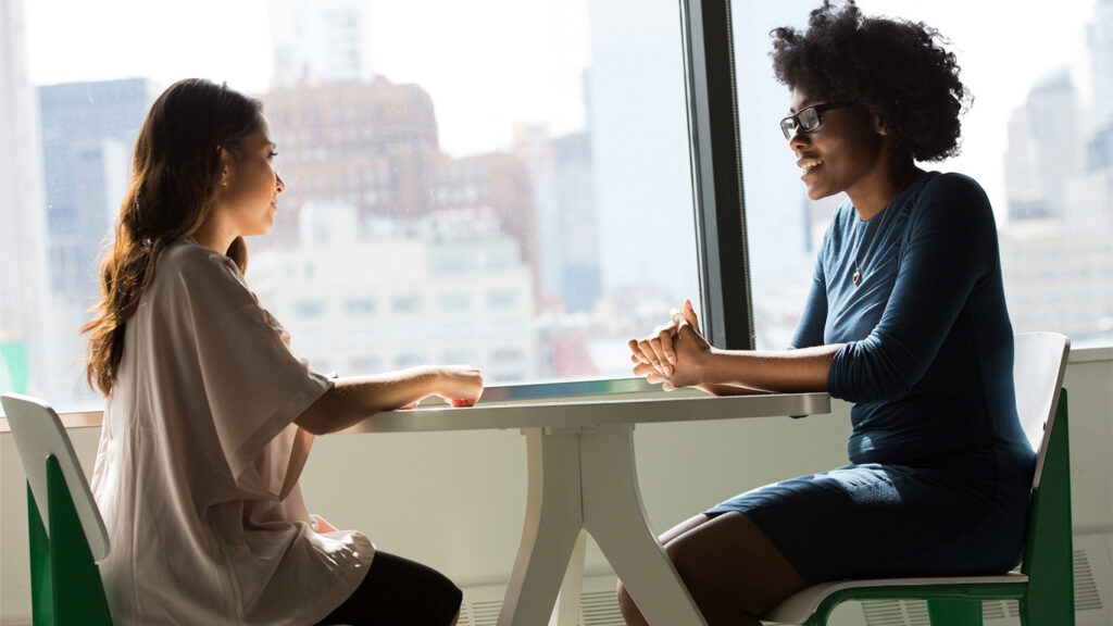Imagem de uma pessoa conversando com outra para remeter o desenvolvimento de seu networking