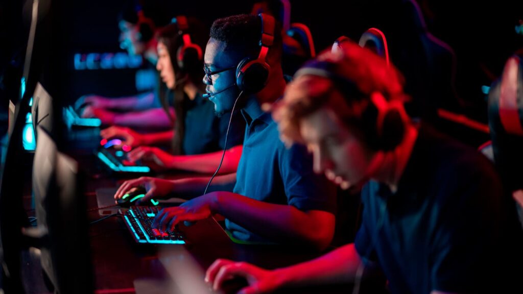 Jovens em frente ao computador em um bootcamp de Engenharia de Software.