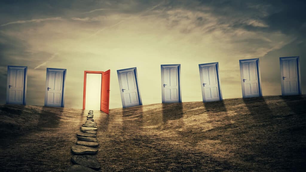 Imagem com portas uma ao lado da outra, todas as azuis estão fechadas e apenas uma vermelha está abera, para simbilizar o ato de escolher um MBA.