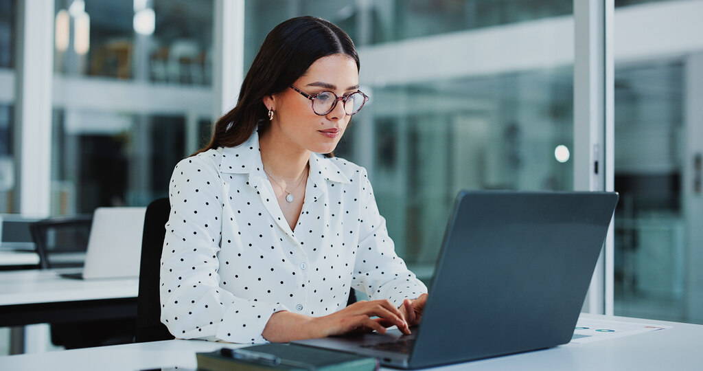 Mulher em escritório utilizando notebook para participar de aulas de MBA em finanças e investimentos.