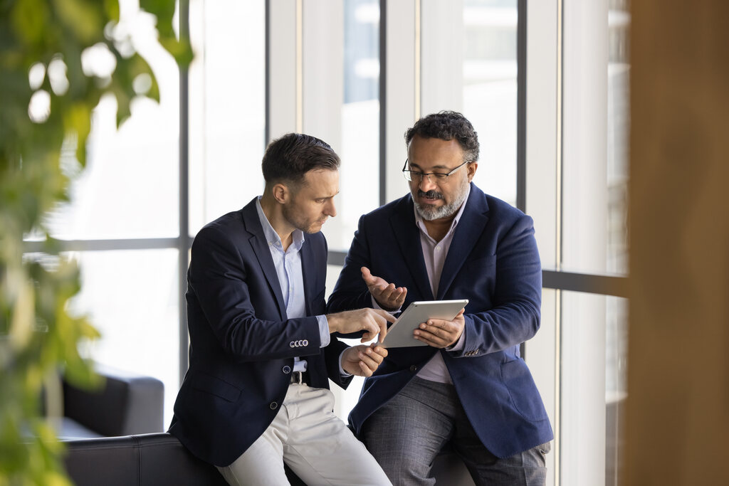 Dois executivos em escritório, conversando sobre o melhor MBA em vendas.
