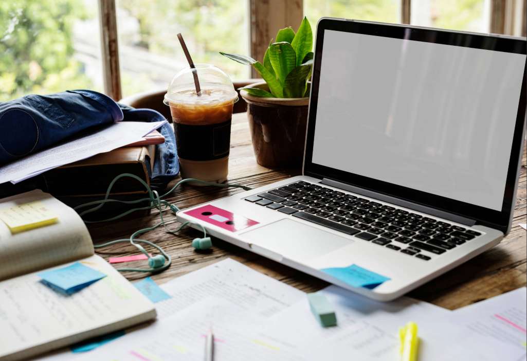 Profissional estudando em casa com notebook e anotações, pesquisando como fazer MBA na USP.