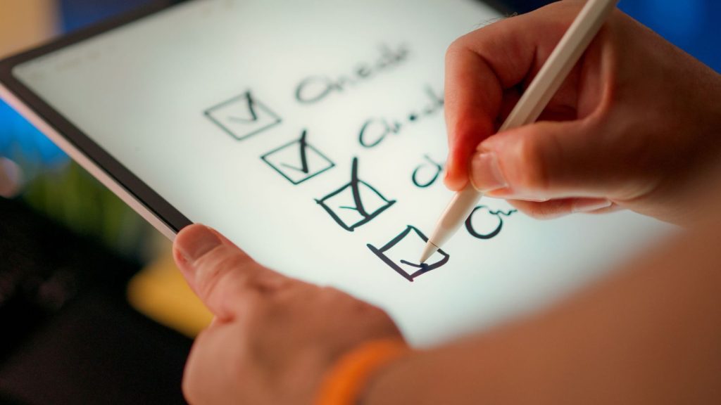 Imagem de uma pessoa fazendo o checklist com critérios para avaliar qual o melhor mba em gestão de projetos.