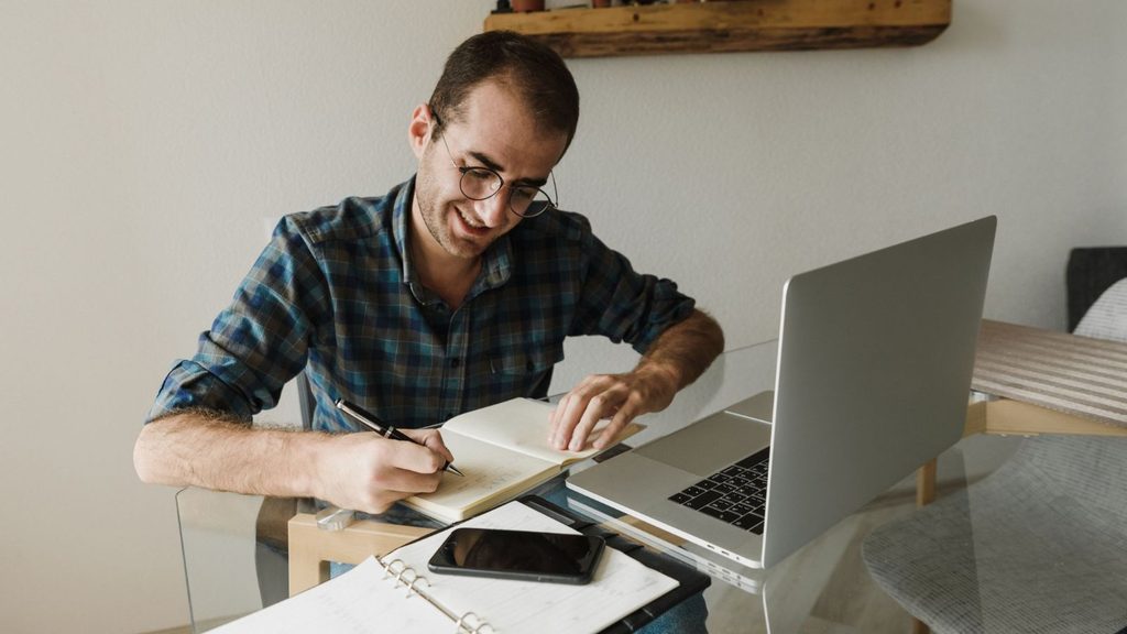 Profissional estudando com notebook para desenvolver conhecimentos e habilidades para a carreira.